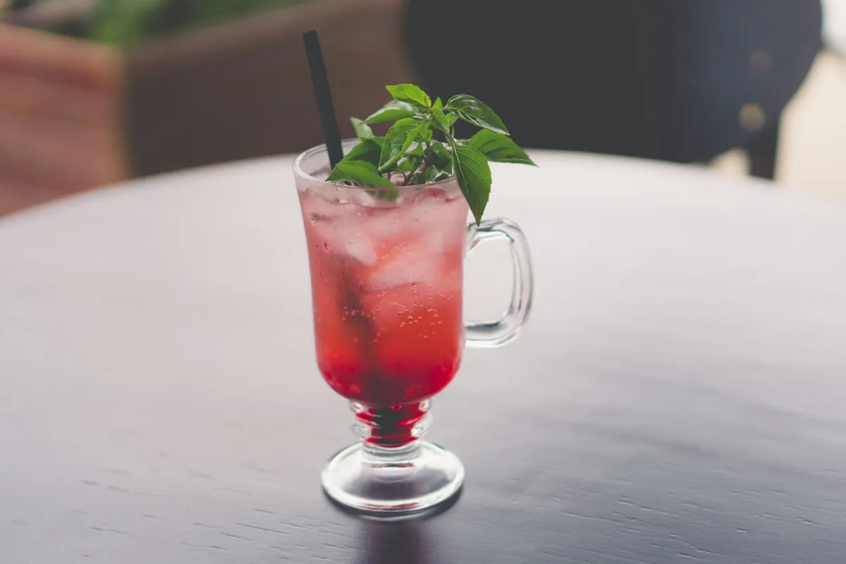 Red sparkling drink with mint and ice, like a 7 Brew Dragons Blood Fizz