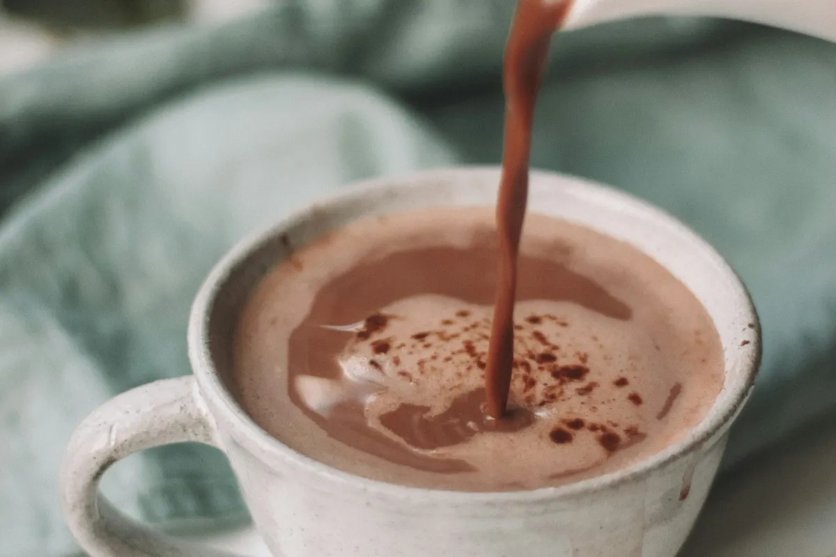 Hot chocolate being poured into a mug, like a 7 Brew Smores Cocoa
