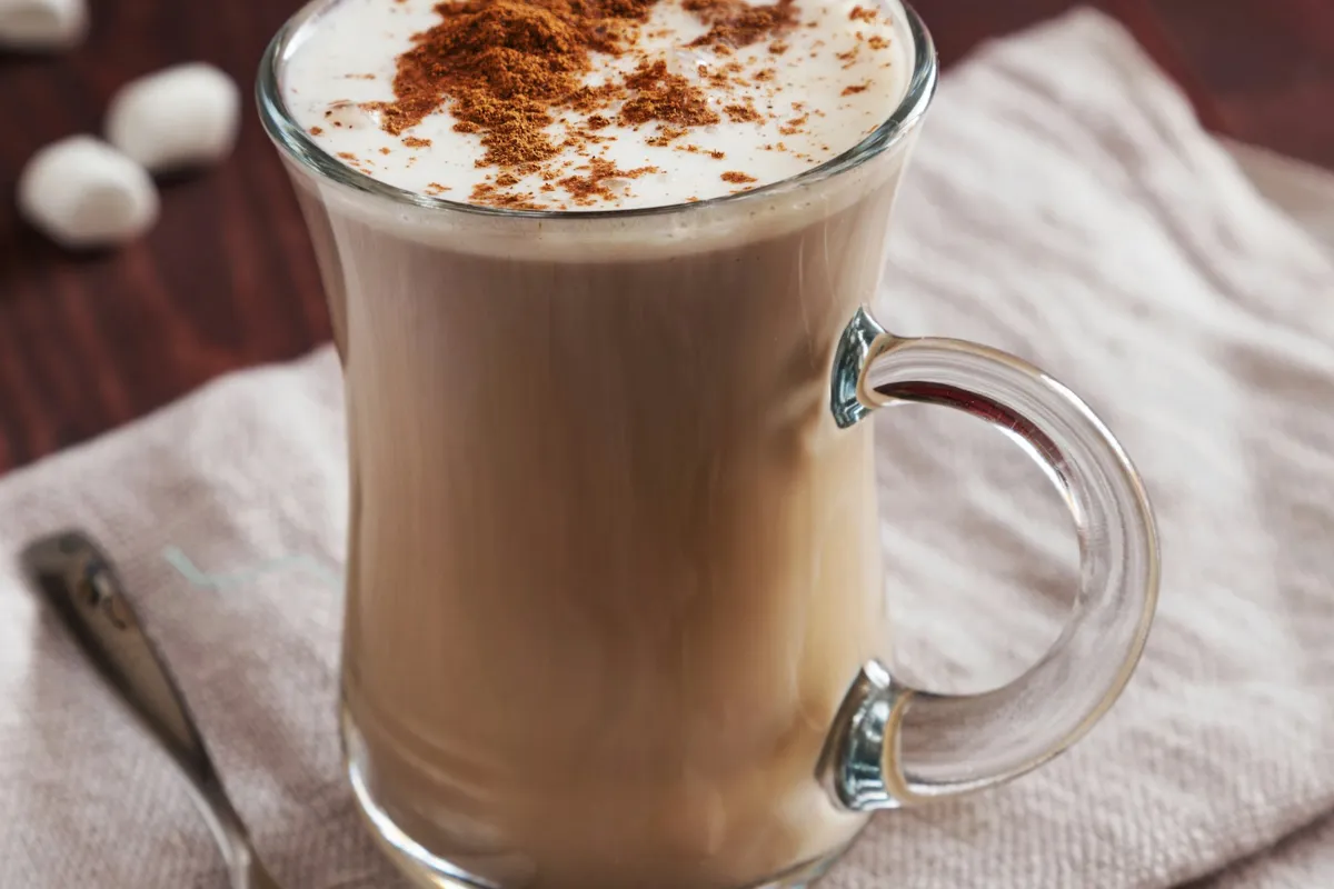 Creamy latte with foam in a glass mug, like a 7 Brew Toasted Marshmallow Latte